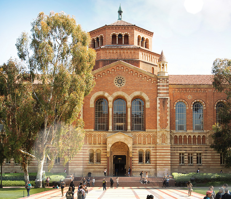 The facade of Powell Library on a blue sky, sunny day.