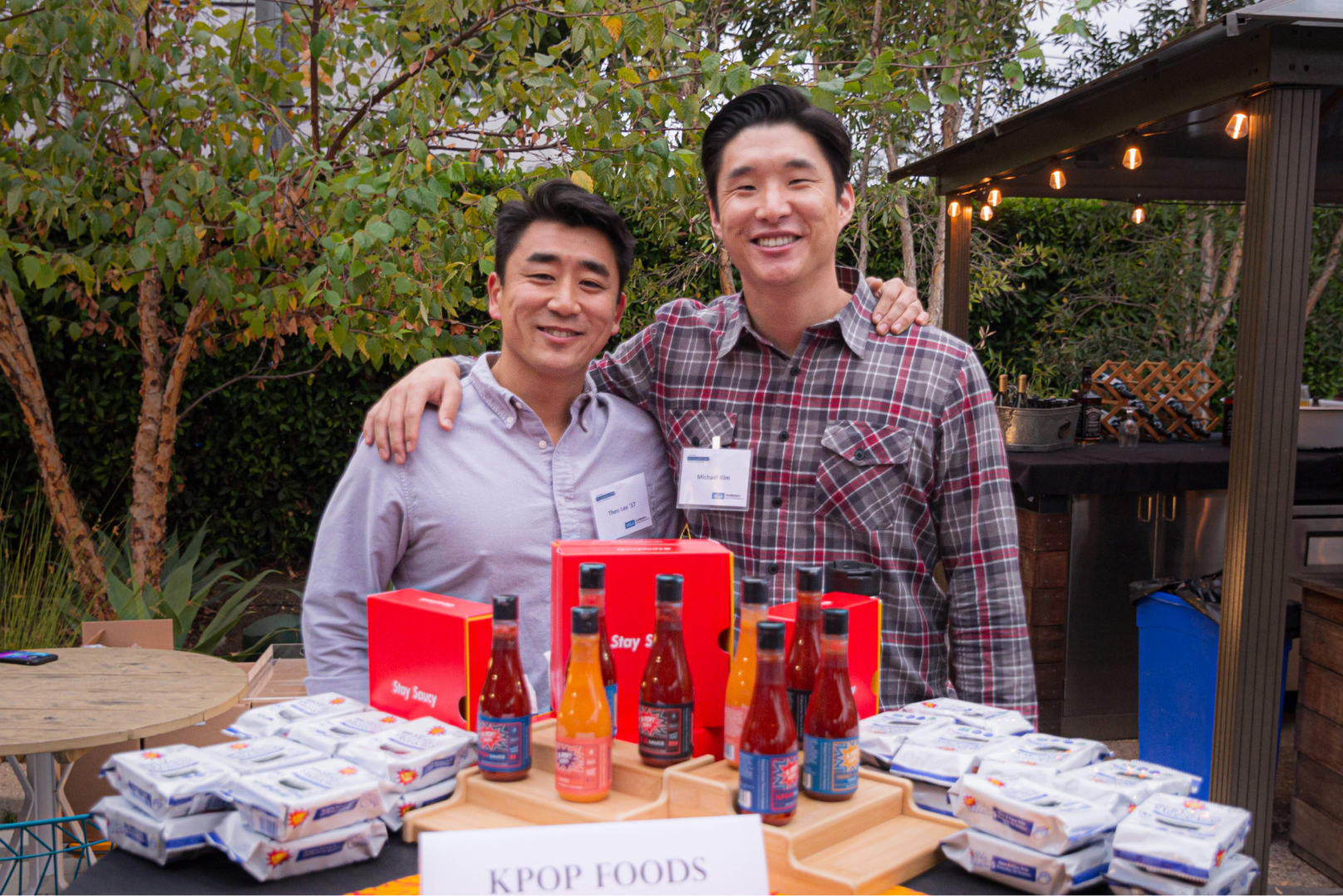 Two enthusiastic entrepreneurs proudly posing in front of their delectable food brand.